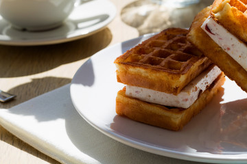 Viennese waffles with cream and grapes on white plate. breakfast