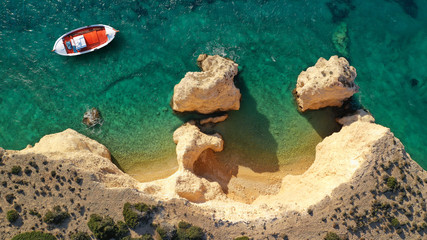 Aerial drone top down photo of traditional red wooden fishing boat in secluded paradise beach of Kasteli in Kato Koufonissi island with turquoise clear sea, Koufonissia, Small Cyclades, Greece
