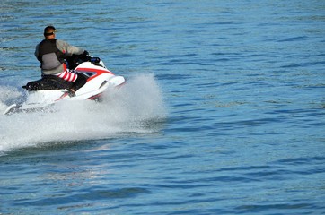 Fototapeta na wymiar Jet skier speeding on the Florida Intra-Coastal Waterway off Miami Beach