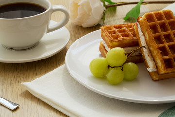 breakfast with coffee and Belgian waffles with fresh fruits on wooden background