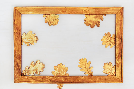 Autumn composition. Gold wooden Frame with autumn golden leaves on light background. Flat lay, top view, copy space