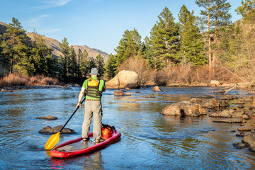 stand up paddling on mountain river