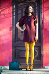 woman in a fashionable burgundy dress and orange pantyhose