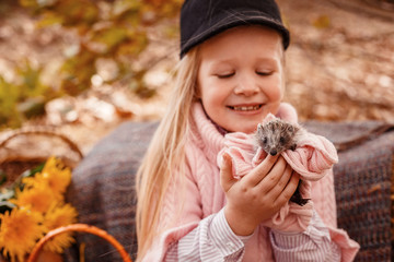 Happy little child girl with cute hedgehog.