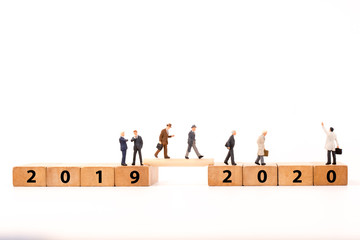 miniature figure backpack  people  walking on number wooden block across from 2017 to 2018 new year