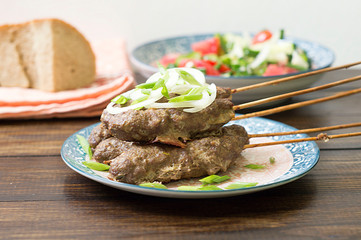 Fried minced kebabs on a wooden table.