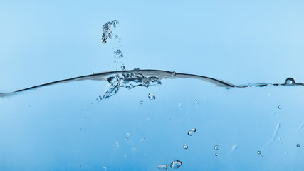 Fototapeta premium wavy transparent water on blue background with splash