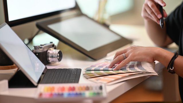 Closeup graphic designer working with selected colour on creative workspace.