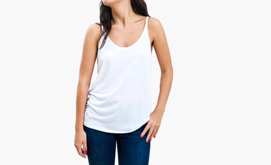 Slender brunette woman wearing casual white tank top and jeans isolated on white background. Blank...