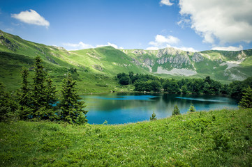 Naklejka na ściany i meble Panoramic view of beautiful mountain range with crystal clear lake