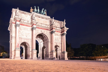 Fototapeta na wymiar Arc de Triomphe on the Carrousel square near the Louvre museum at night, illuminated by lights and lanterns on long exposure