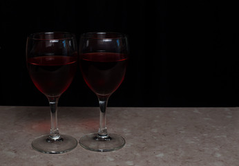Two red wine glassen on a black backgound