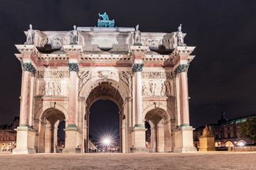 Fototapeta na wymiar Arc de Triomphe on the Carrousel square near the Louvre museum at night, illuminated by lights and lanterns on long exposure
