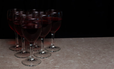 Six red wine glassen on a black backgound