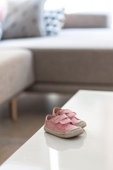 Pink baby girl sneakers on an indoor white table