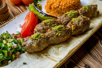 Lula kebab with pistachios Turkish cuisine on wooden table