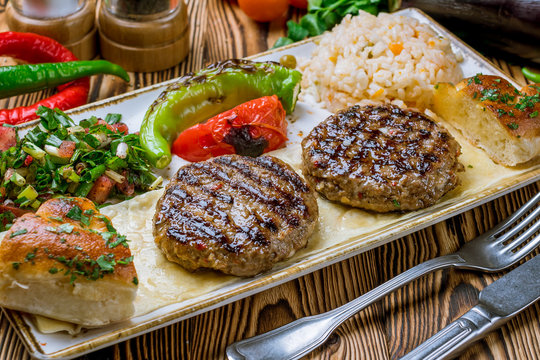 Cutlets with cheese in tomato sauce in Turkish on wooden table