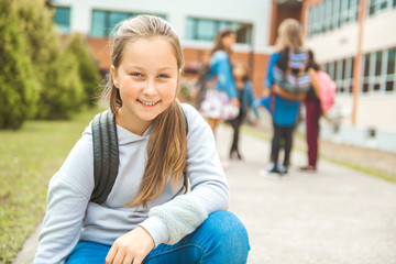 A student school girl on the playground on the first day of class