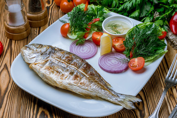 Dorado on grill on wooden table