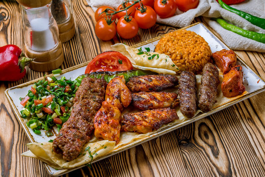 assorted kebabs with bulgur and vegetables Turkish cuisine on wooden table