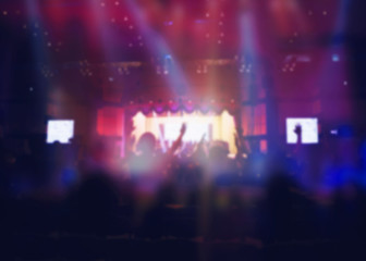Blurred of Christian Congregation Worship God together in Big Church hall in front of music stage and light effected.