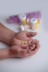 rugged working hands of a man holding  pain medication prescription bottle on white. shallow depth of field