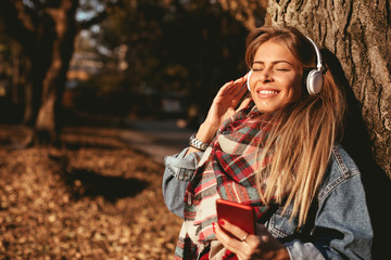 Young woman in the park listening to music