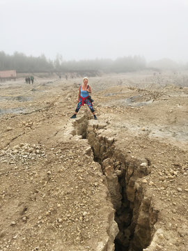 Woman straddling a crevice post earthquake at an open cast mine, Lithuania