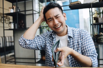 portrait of young man with empty wallet.