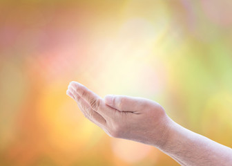 Fototapeta na wymiar adult man hands raise up to the sky over blurred yellow background can be used for Christian concept or background of praise and worship or prayer with copy space for your text
