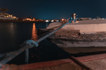 long time exposure of a boat in El gouna lagoon with a view of a hotel in the night and stars in the air.