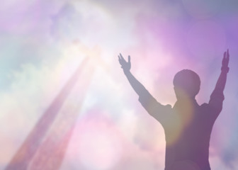 soft focus and Silhouettes of man raise hand up worship God over the cross in cloudy sky . Christian background with copy space for your text