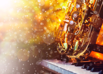 Close up of Saxophone on piano keys near Christmas decoration table with bokeh light effected, Copy space