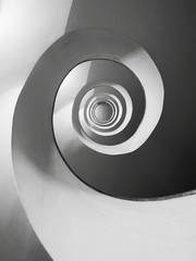 Black and white photograph of a spiral staircase inside a building.