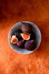 fresh ripe figs in white bowl on vibrant background. top view