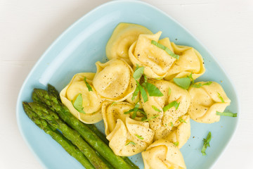Ravioli with asparagus on a blue plate