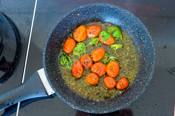 Tomatoes are fried in a pan