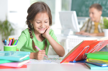 Cute teen girl doing homework in her room