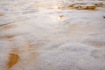 Remains of soap foam, bubbles and water scattered on the ground.