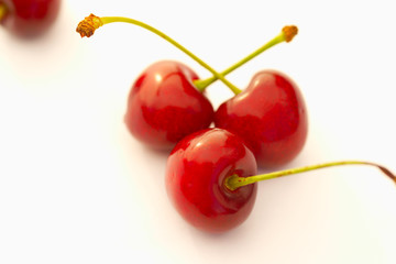 Obraz na płótnie Canvas Study of Three (3) red Cherries against white