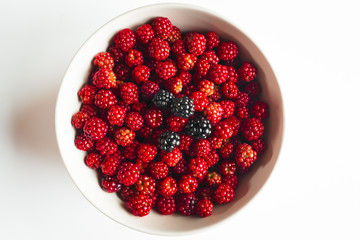 bowl with many red mulberry and some blackberry