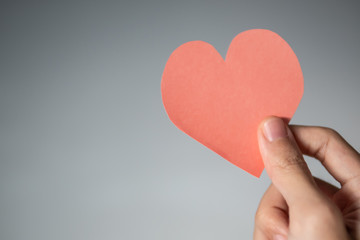 World heart day concept. Heart shaped paper in hand.