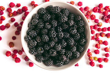 bowl with many blackberries and some red mulberry