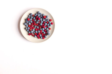 a plate with red berries and blackthorn