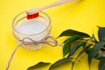 Wooden brushes, tooth powder, on a yellow background. Zero waste concept, close up.