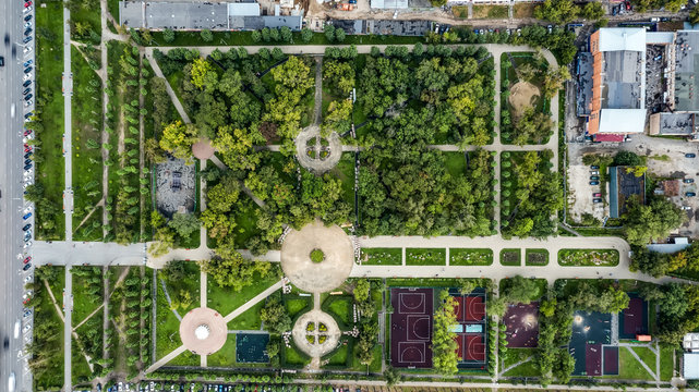 Aerial shot of beautiful metropolitan Park with tree paths, sports grounds.