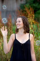 young brunette woman standing outdoors with soap bubblesyoung brunette woman standing outdoors with soap bubbles