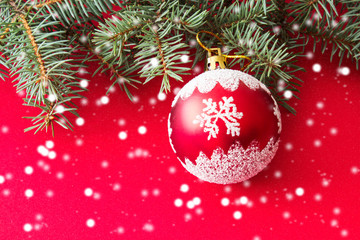 Obraz na płótnie Canvas Christmas and New Year background. Colorful christmas composition with xmas tree branches and christmas balls. Christmas tree toy on a red background. Place for text.
