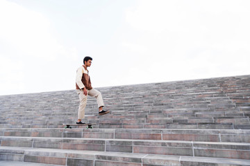 Afro man with skate running up flight of stairs