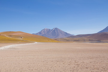 Beautiful mountain landscape with road over vast sand terrain. Atacama Desert - Chile. Miniques / Miscanti lagoons.